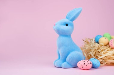 Süslü Paskalya tavşanı ve pembe arka planda Paskalya yumurtaları. Uzayı kopyala Seçici odak.