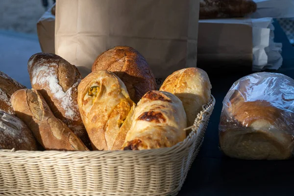 A basket of bread at a farmers market viwed from the side under natural light- real life market photograph