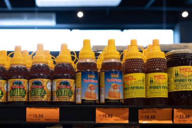 Petropolis, RJ, Brezilya. 19 Aralık 2023. Apiario da Serra, Imbiara, Apiario Friburgo markalarının altında fiyat etiketleri bulunan çeşitli bal şişeleriyle süpermarket rafı.