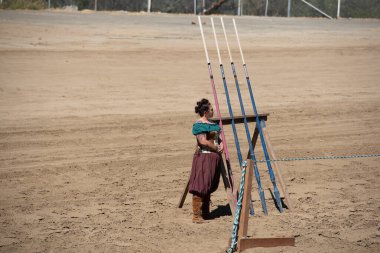 Folsom, CA, 24 Eylül 2022. Folsom Rönesans Fuarı 'nda kimliği belirsiz bir kadın mızrak dövüşü için mızrakları izliyor.