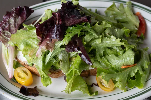 アボカドトーストの上の生レタスとトマトサラダ レストランの設定でのディナーアングルの眺めとクローズアップ 健康的な低カロリーの食事 — ストック写真