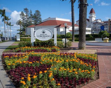 San Diego, CA 'dan. 5 Nisan 2024. Otel del Coronado hoş geldin tabelası ve bahçe. 1888 'de inşa edilen bu otel, Coronado adasında tarihi bir turistik merkezdir.. 