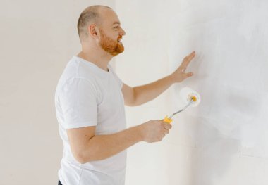 Boya silindiriyle duvarları boyayan adam. Tamirci, ev yenileme ve yenileme konsepti. Yüksek kalite 4k görüntü