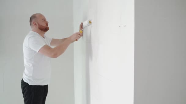 Maler Mann Beim Bemalen Einer Wand Mit Einer Walze Haussanierungen — Stockvideo