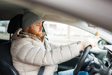 Angry driver in a traffic jam. He screams and gesticulates, Furious man gesticulates with hands and horns driving on traffic jam. Crazy driver yelling from car desperately.