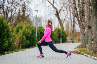 Woman performs stretching before jogging. High quality photo