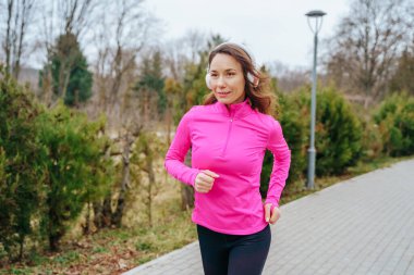 A solo female jogger enjoying the fresh air and the freedom of movement that comes with jogging in a natural, outdoor environment.