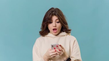 A charming and attractive teenage girl is seen in a photo, holding a smartphone and looking happy and satisfied. Her choice of item is astonishing and her expression is stunning.