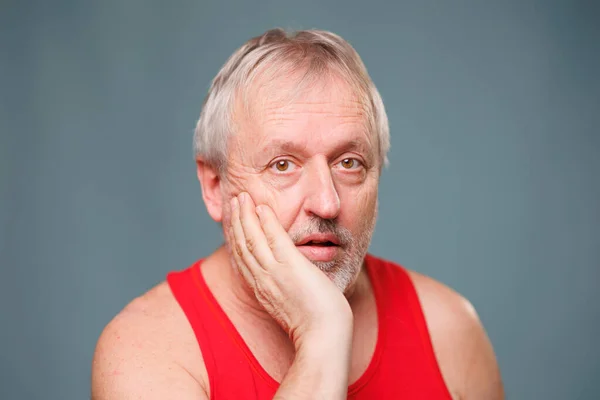 Astonished Senior Portrait of an amazed elderly man, looking intently and shocked in a studio setting. The man, a senior citizen of caucasian descent, is staring in wonder and overwhelmed
