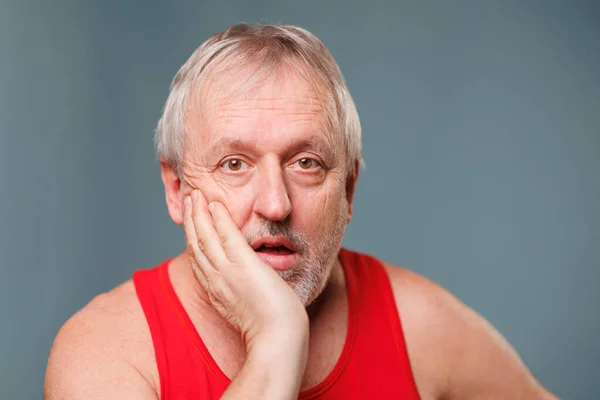 Surprised Elderly A male senior is captured in a portrait, staring in surprise and puzzlement. The man is of caucasian descent and is an older, elder adult. This image is a studio shot of a senior