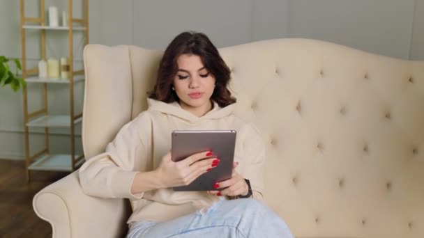 매력적 사춘기 소녀는 거실에 소파에 비디오 통화를 누군가와 의사소통을 하면서 — 비디오