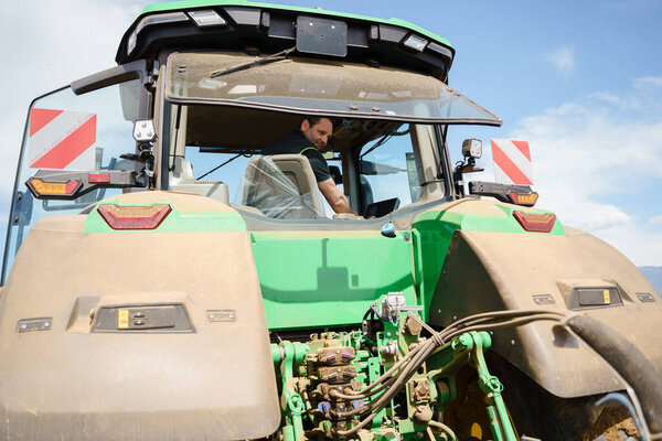 A farmer using a tractor to prepare the fields for planting. The image highlights the importance of soil preparation and the use of modern farming techniques and equipment in achieving better