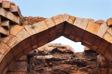 Eski kırmızı kumtaşı minare eski mimari ve eski kemerli inşaat alanı. Kutub kompleksinin bir parçası Delhi, Hindistan 'da Mehrauli' de bir dizi anıt ve bina. UNESCO Dünya Mirası Alanı