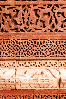 İslami semboller, duvarlar pürüzsüz desen - geleneksel İslami arka plan. Taş oymalı duvarın dekoratif elementi. Kutub (Kutub) M.S. 1199 yılında Minar kırmızı kumtaşı ve mermer. Unesco Dünya Mirası. Hindistan.