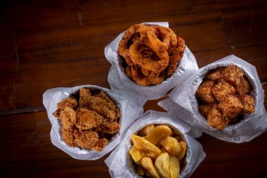 Kızarmış abur cubur menüsü: patates, tavuk, tapyoka küpleri ve soğan halkaları.