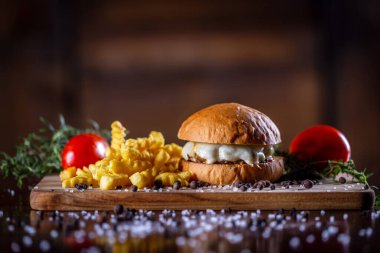 Peynirli sığır burger ve ahşap arka planda patates kızartması.