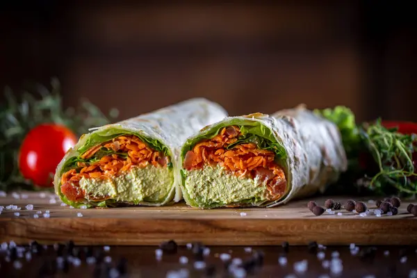 Vegetarian wrap sandwich on wooden background