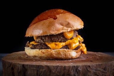 Çedar peynirli ve sarımsak soslu iki ezilmiş burger.