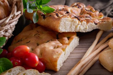 Koyu arkaplandaki ahşap masada sepetteki ekmek çeşitleri. Fırın Çeşitliliği.