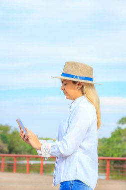 İş gününün sonunda şapka ve kot giyen bir tarım işkadını.