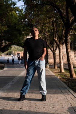 İkili oynamayan Latin makyajlı biri şehir sokağının ortasında dikilirken kameraya bakıyor. LGBTIQ çeşitlilik kavramı.