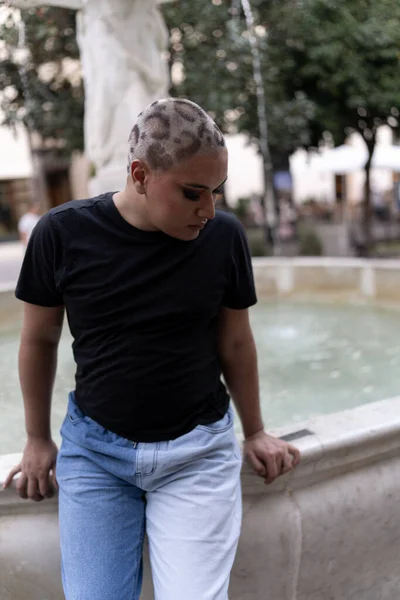 Young Non Binary Person Looks While Sitting Outdoor Water Fountain — Stock Photo, Image