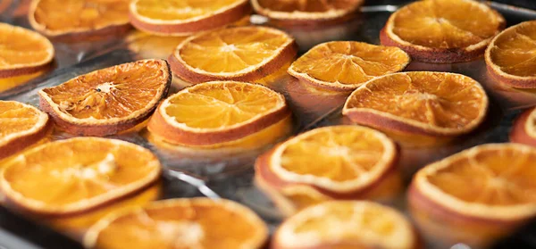 Background. Food. Oranges are cut into thin slices on a baking sheet baked in the oven. Close-up. Soft focus. Concept.