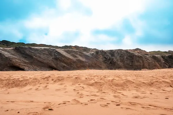 stock image A tranquil beach, a rocky outcrop, and the soft sand, capturing the serene beauty of coastal nature.