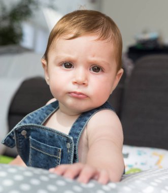 Düşünceli şirin bebek kameraya bakıyor.