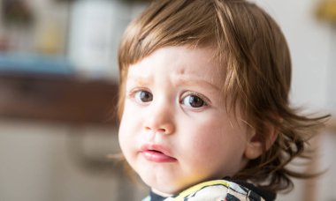 Portrait of a baby boy with an unhappy expression