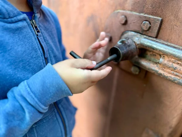 Çocukların yakın plan çekimleri demir kapıyı açıyor. Çocuk kapıyı kilitliyor. Yüksek kalite fotoğraf