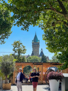 People on street in Luxembourg City and Spuerkess Klochk Tower background . Vertical photo clipart