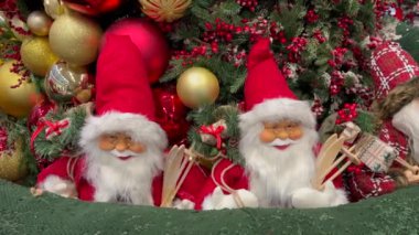 İki Noel Baba heykelciği Noel süsleriyle çevrili.