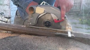 Marangoz dairesel testere ile tahta keserek talaş üretiyor.