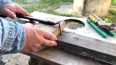 İşçi, tahta çivileri çekiç ve tahta blokla söker.