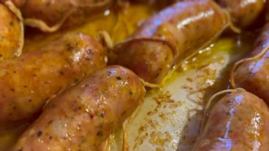 Lezzetli sosisler fırında kızarıyor, sulu tatlar yayıyor.