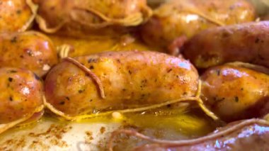 Lezzetli sosisler fırın tepsisinde kızarıyor.