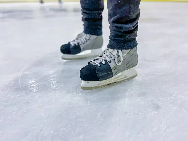 Buz hokeyi oyuncusunun buz pistinde duran buz pateni giyen alt kısmı.