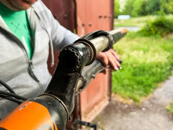 Bir tamirci tarafından tamir edilen bisiklet sapının yakın çekimi, hasarlı bileşenin karmaşık detaylarını vurguluyor