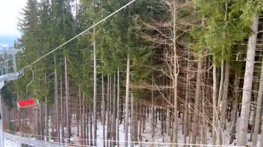 Boş teleferik karlı ormanda ilerliyor.