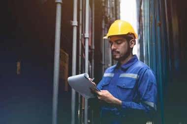 Asian industrial man doing routine stock checking at container yard. clipart