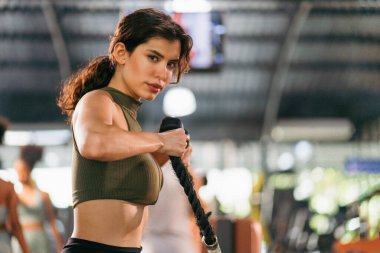 Odaklanmış ve kendinden emin bir tavırla spor yapan genç bir sporcunun portresi. Kadınların zayıflaması ve güçlenmesi için sağlık hizmetleri popüler yaşam tarzı egzersizi.