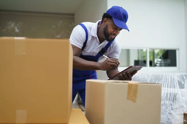 Afrikalı Kurye Taşıyıcısı Müşteriye Taşınmadan Önce Karton Kutucuğu Işaretliyor — Stok fotoğraf