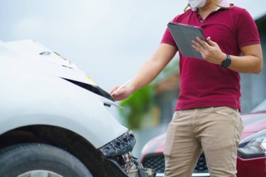 Sigorta acentesi kazadan sonra arabayı incelerken tablete yazmanın yan görünümü