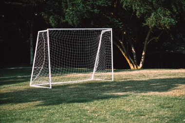 Football goal put on the grass field without people in the park. A mini net goal at playground for small groups people can have exercise activities and leisure. clipart