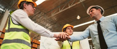 Asyalı endüstriyel işçilerden oluşan panoramik görüntü grubu işlerini tamamladı ve iş başarısı ve mutluluğu elde etmek için el veya el ele birleştirme çalışmalarını tamamladı..