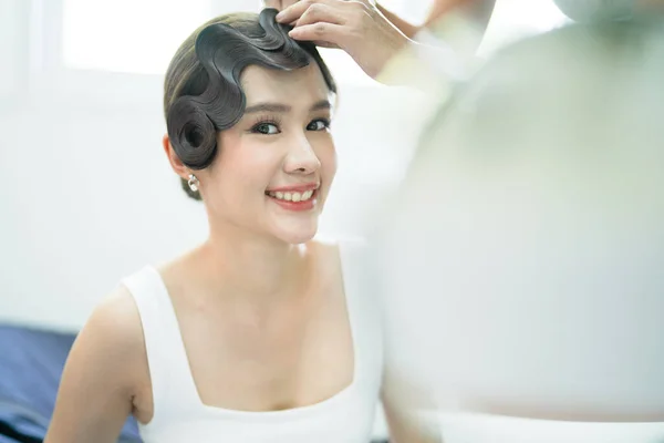 Behind the scene of Vintage style hair makeover shot of asian woman smile gorgeously toward mirror, dress up , preparing for party, wedding , celebrate traditional event, Chinese lunar new year.