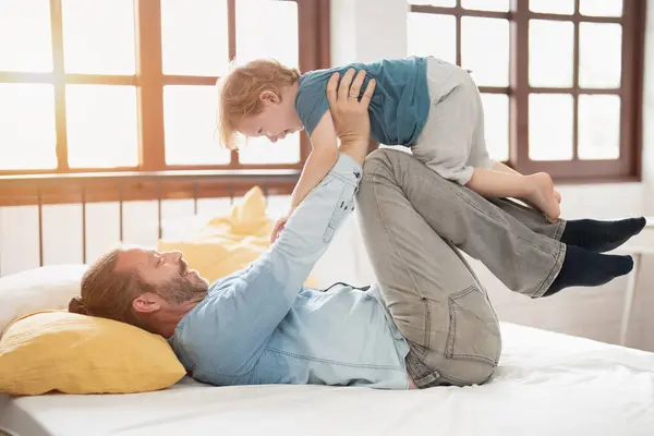 Happy father lying and lift up son or daughter in airplane gesture, playing and spend family quality time,   happy family, with love and care, parent and child, father bond.