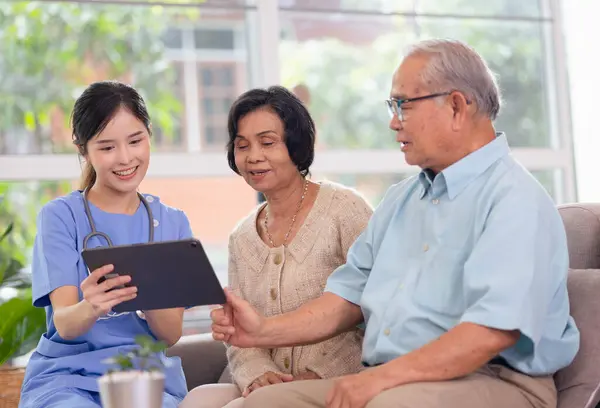 Health care consultation by young Asian woman nurse give a friendly consult to couple elderly by tablet. Concept Nursing home care.