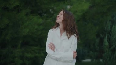 Gülümseyen genç bir kadının yakın çekimi. Neşe, pozitiflik ve sevgi. Güzel kıvırcık esmer saçlar. Sinematik 4K. Ağır çekim. Yüksek kalite 4k görüntü